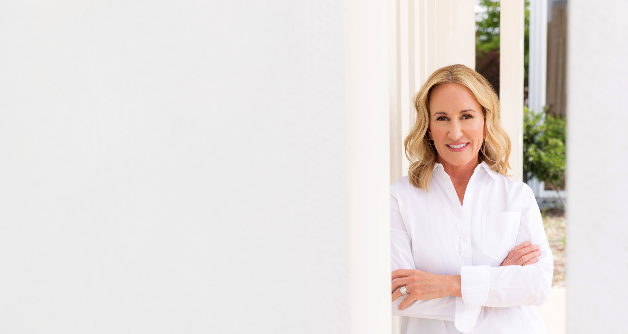 Doctor Melissa Rozas in a white buttoned blouse leaning against a wall